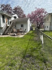 Mowed side yard between homes with a chain-link fence.