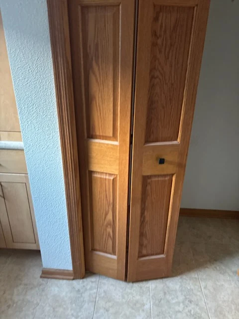 Two stained wood bifold closet doors installed in an interior opening.