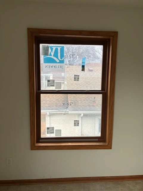Installed double-hung window with natural wood interior trim.